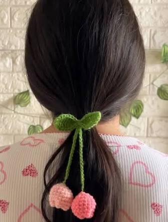 A girl wearing a handcrafted crochet tulip hair tie holding up their hair in a ponytail.
